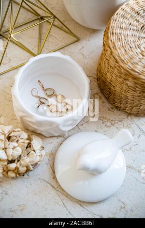 In stile country Home decor, gioielli casella e cesto di vimini sulla tavola di marmo di close-up Foto Stock