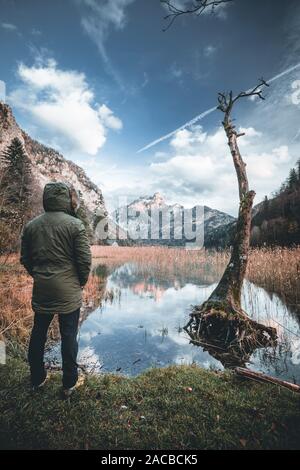 Rilassata escursionista gode di una stupenda vista sulla montagna e sul lago in Austria Foto Stock