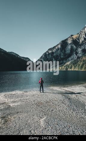Rilassata escursionista gode di una stupenda vista sulla montagna e sul lago in Austria Foto Stock