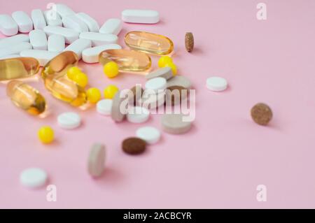 Assortiti medicina farmaceutica pillole, compresse e capsule su sfondo rosa. Vista dall'alto. Lay piatto. Copia dello spazio. Il concetto di medicina. Cumulo di pillole su pi Foto Stock