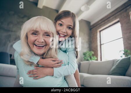 Basso angolo di seguito visualizzare foto di due migliori amici gente carina età granny piccola ragazza nipote abbraccio piggyback giocare gioco divertente trascorrere il fine settimana insieme Foto Stock