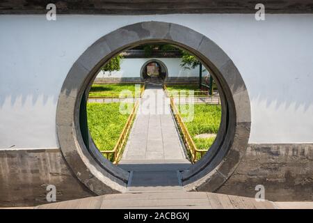 In stile minimalista porta a forma di cerchio, attraverso cui neat prati sono visibili con l'erba. Foto Stock