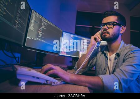 Vista bassa ritratto della sua egli bella attraente focalizzato grave preoccupazione guy tech manager risponde alle chiamate che fornisce guida remota del servizio di assistenza di fronte Foto Stock