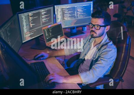 Ritratto di sua egli bella attraente focalizzata brunette guy creazione di script di codifica html java database mysql utilizzando lingue software lavora sodo al buio Foto Stock
