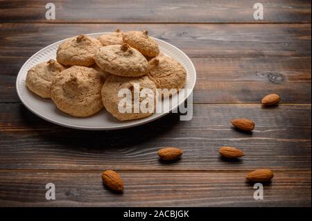 Biscotti di mandorla su una piastra su un tavolo di legno Foto Stock