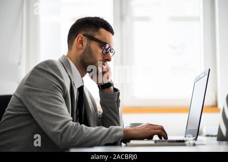 Giovane imprenditore sta lavorando in ufficio. Foto Stock