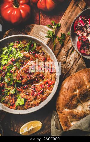 Babaganoush immersione a freddo condito con prezzemolo e i semi di melograno e flatbread Foto Stock