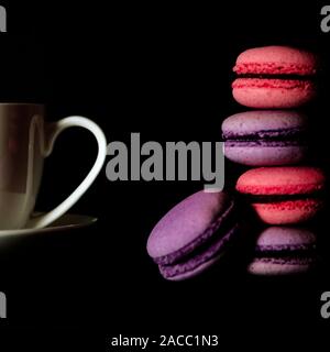 Macarons su sfondo scuro e colorati di biscotti francesi macaron. Macarons Foto Stock