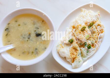 Vista superiore tradizionale cibo cantonese di cheong fun Riso o Noodle rotoli e ciotola di porridge Foto Stock