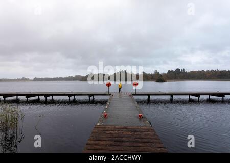 La madre e il bambino in piedi su un molo in legno dal lago, Irlanda Foto Stock