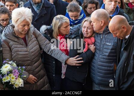 Jack Merritt della madre Anne (estrema sinistra), fidanzata Leanne O'Brien (centro) e padre David (seconda a destra) durante una veglia alla Guildhall di Cambridge in onore di lui e Saskia Jones dopo le due di loro sono stati uccisi nel venerdì di London Bridge attacco terroristico. Foto Stock