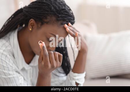 Oro anello di nozze in mano di sconvolgere nero donna Foto Stock