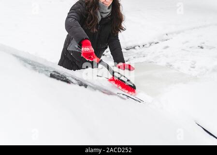 Donna auto pulita con una spazzola dopo neve Foto Stock