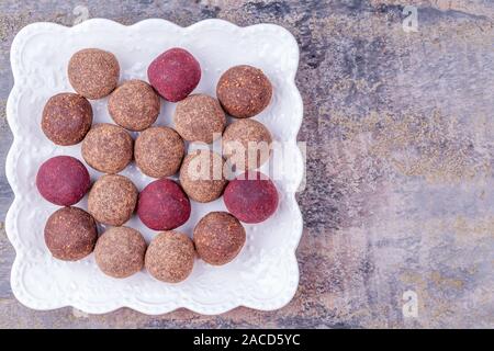 In casa materie Vegan Cacao sfere di energia sulla piastra bianca su grigio Sfondo marmo Foto Stock