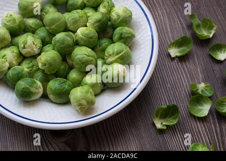 Close-up di alcuni freschi organici e i cavoletti di Bruxelles su una piastra Foto Stock