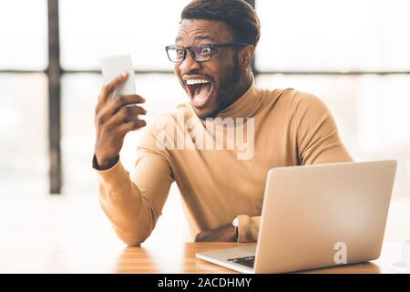 Sorpreso ragazzo nero vincere soldi in lotteria Foto Stock