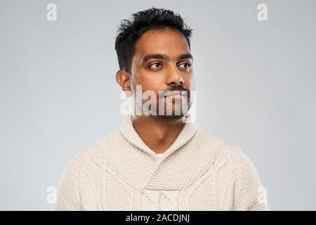 Indian uomo in felpa lavorata a maglia su sfondo grigio Foto Stock
