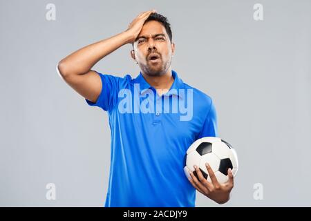 Sconvolto maschio indiano tifoso di calcio con sfera Foto Stock