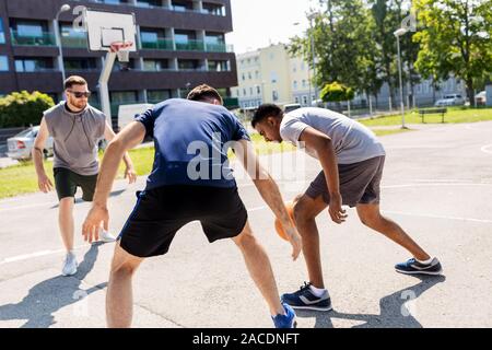 Gruppo di amici maschi giocando street basket Foto Stock