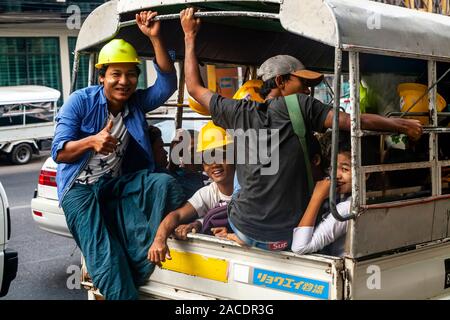 Birmani sorridente lavoratori edili in un pick up Truck, Yangon, Myanmar. Foto Stock