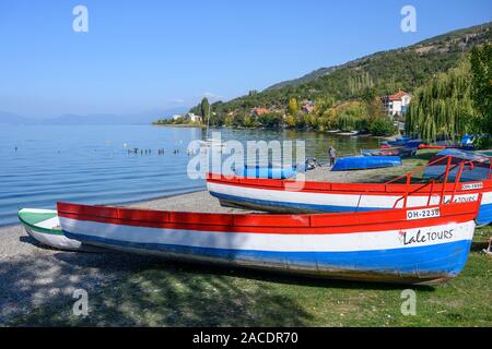 Colorate barche a remi sulla riva del lago di Ohrid a Peshtani nel nord della Macedonia, l'Europa. Foto Stock