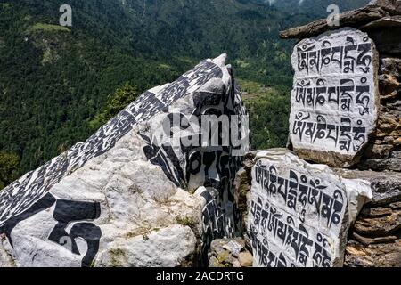 Grandi Mani pietre con inciso il mantra tibetano OM MANI PADME HUM, situato all'entrata del villaggio Foto Stock