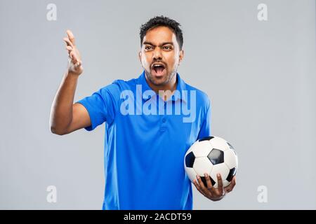 Arrabbiato maschio indiano tifoso di calcio con sfera Foto Stock