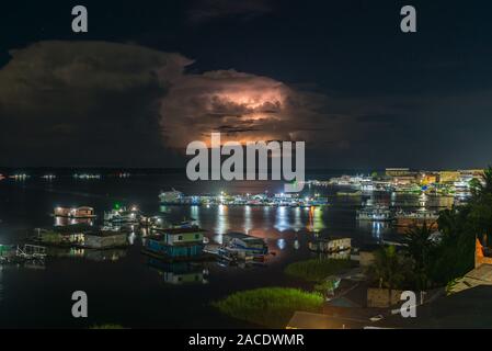 Il fulmine dietro le nuvole di notte, la vivace città di Tefé sul Lago di Tefé, Amazona River, Amazon Membro, Northern Brasilia, America Latina Foto Stock