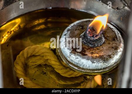 Incendio in olio lampada lanterna, vicino. Uno stoppino con una fiamma nuota in olio all'interno di una lampada. Foto Stock