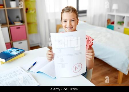 Ragazza dello studente con la scuola test buon segno a casa Foto Stock