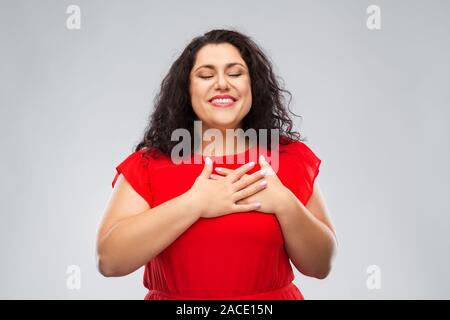 Donna felice tenendo le mani sul petto o cuore Foto Stock