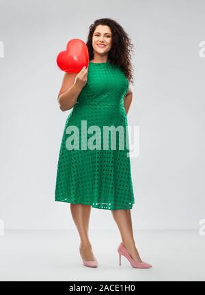 Donna felice azienda cuore rosso a forma di palloncino Foto Stock