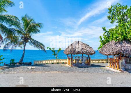 Tropical vedute panoramiche dell'oceano con palme e capanne dalla Repubblica Dominicana. Foto Stock