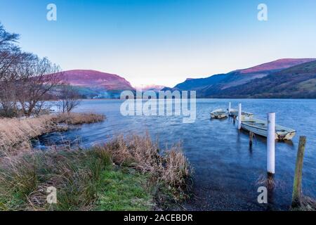 Barche ormeggiate su Llyn Nantlle lago al tramonto. Mount Snowdon in distanza. Parco Nazionale di Snowdonia, Gwynedd, Wales, Regno Unito, paesaggio, ampio angolo Foto Stock