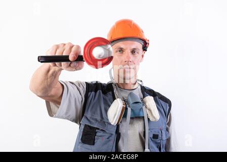 Un builder in un casco con silicone in una pistola di montaggio, mira al telaio. Foto Stock