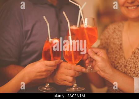 Gruppo di amici cheers con aperol spritz nel ristorante. Il vino italiano cocktail di base Foto Stock