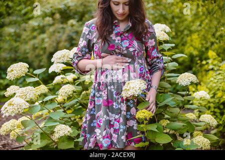 Ritratto di bella donna incinta in giardino Foto Stock