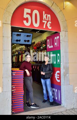 Donne assistenti shop in piedi nella porta del prezzo fisso, 50 Kuna, 7 eur Porec, in Croazia Foto Stock