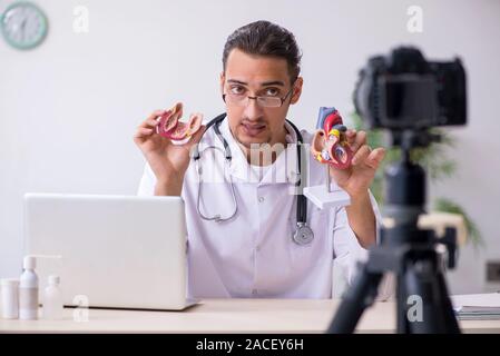 Il giovane maschio medico cardiologo di registrazione di video per il suo blog Foto Stock