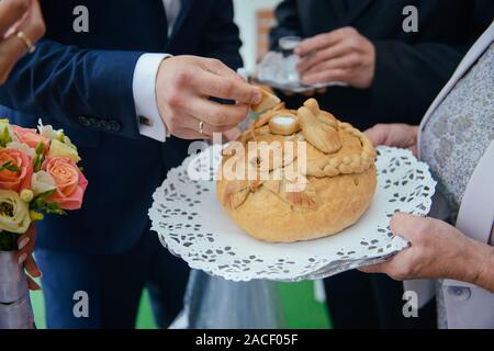 Tradizionale polacco saluto la sposa e lo sposo dai genitori con il pane e il sale. La vodka anche in bicchieri. Foto Stock