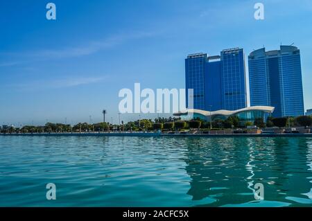 Abu Dhabi skyline della città lungo la Corniche beach presi da una barca negli EMIRATI ARABI UNITI Foto Stock