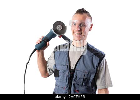 Un builder in un casco e un respiratore, con una smerigliatrice angolare sulla sua spalla. Sorrisi. Foto Stock