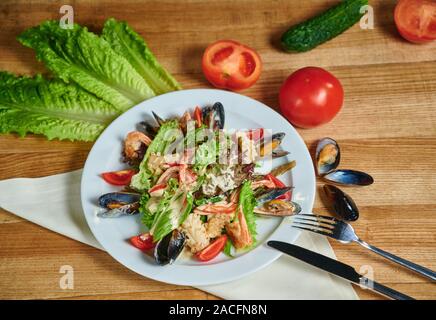 Una sana insalata con gamberetti, cozze, pomodori e foglia di lattuga, close-up Foto Stock