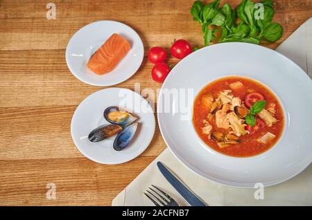 Pomodoro siciliano zuppa di pesce. Zuppa di cozze e pesce. Bel piatto. La disposizione di posate Foto Stock