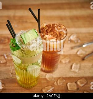 Due bicchieri con bevande rinfrescanti. Deliziose acque rinfrescanti con il cetriolo e la cannella in bicchieri Foto Stock