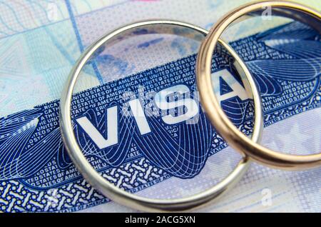 Foto macro di noi entrata vignetta visto in un passaporto e un paio di anelli. Foto concettuale per l'immigrazione. Messa a fuoco selettiva. Foto Stock