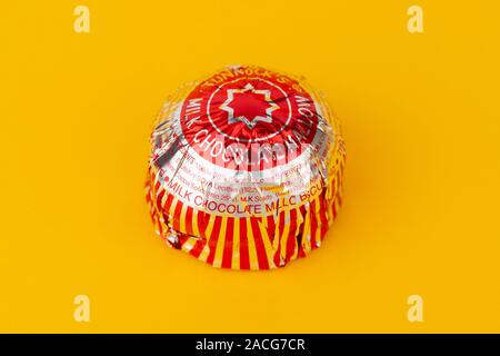 Un Tunnock il cioccolato al latte Torta di tè shot su sfondo giallo. Foto Stock