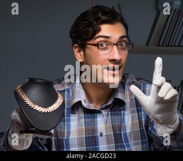 Il giovane maschio gioielliere lavorando di notte nel suo laboratorio Foto Stock