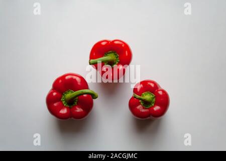 Tre peperoni rossi isolato su sfondo bianco da un elevato angolo di visione Foto Stock