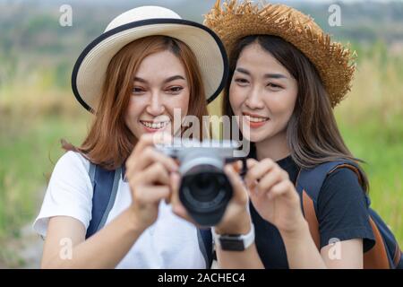 Due donna turistica di scattare una foto con la sua macchina fotografica in natura Foto Stock